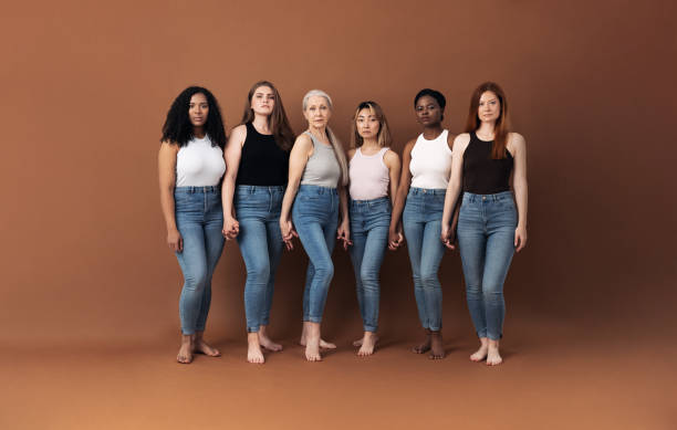 istock Six serious women standing together holding hands in studio 1331892548