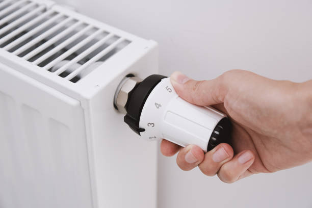 istock Woman hand adjusting temperature on heat radiator 1331896400
