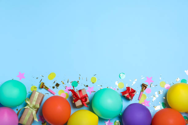 istock Flat lay composition with balloons and confetti on light blue background, space for text. Birthday decor 1331899741