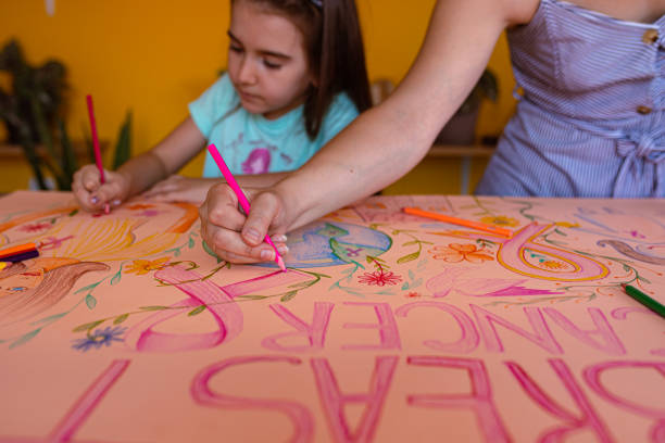 mother using creative time to teaches her daughter about breast cancer awareness - community outreach connection child paper imagens e fotografias de stock