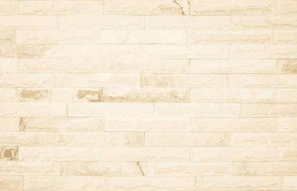 istock Empty background of wide cream brick wall texture. Beige old brown brick wall concrete or stone textured, wallpaper limestone abstract flooring/Grid uneven interior rock. Home decor design backdrop. 1331904094