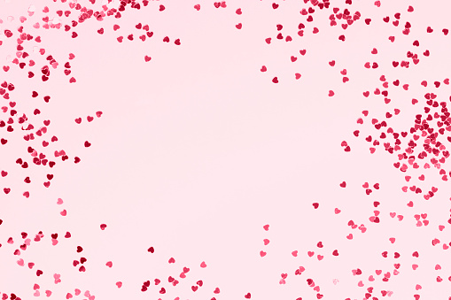 Pink pastel background with pink glittering hearts. Place for your text.