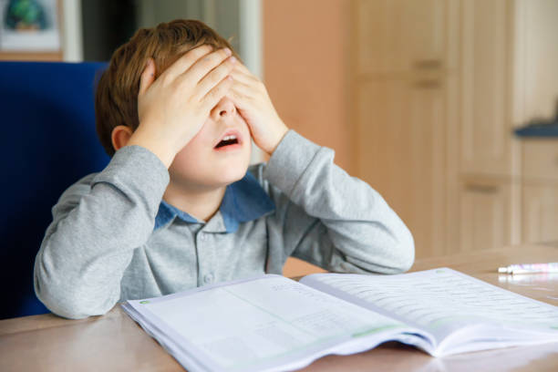 istock Upset school kid boy making homework during quarantine time from corona pandemic disease. Crying and sad boy frustrating staying at home. 1331908281