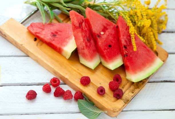 istock watermelon and watermelon pieces in a wooden background. 1331908304