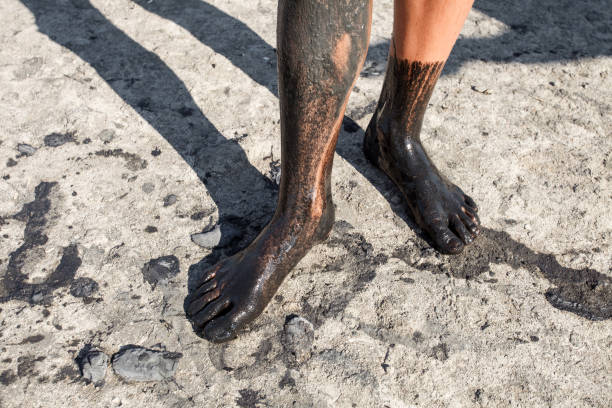 치료 진흙에 얼룩진 아이의 소년의 발은 말린 토양에 서 있었다. - hands and feet flash 뉴스 사진 이미지