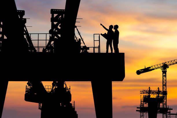 istock Silhouette of Engineer and worker checking project at heavy infrastructure building site background, construction site at sunset in evening time. 1331910027