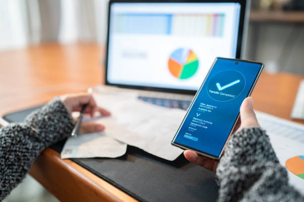 mulher usando aplicativo bancário na conta de luz de pagamento do smartphone, conceito de internet banking de tecnologia financeira - pagando - fotografias e filmes do acervo