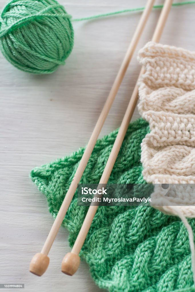 Two bright patterns and wooden knitting needles for a white background Knitting Needle Stock Photo