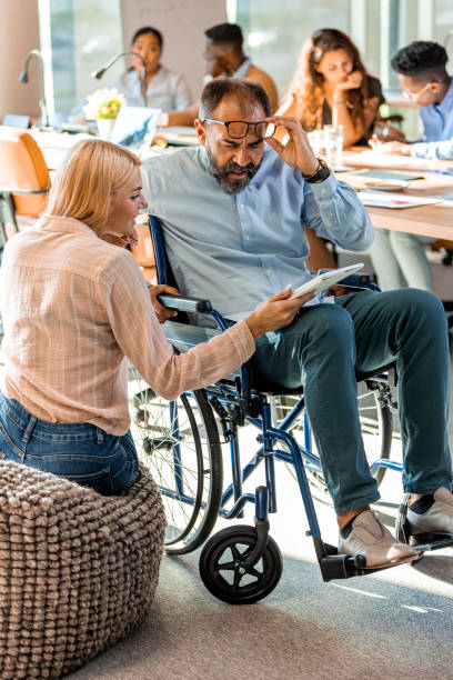 istock Disabled businessman discussing with colleague 1331917702