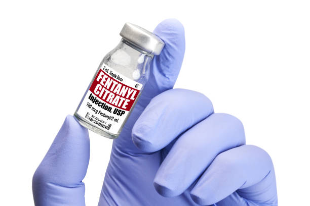 Fentanyl drug addiction - Hand holding vial on white Fentanyl in vial. Gloved hand holding on white background fentanyl stock pictures, royalty-free photos & images