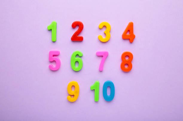 istock Magnetic multi-coloured numbers on purple background with copy space. Back to school. 1331919755
