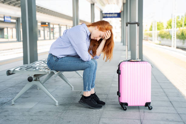 Young woman waiting sitting in train station platform Hopeless woman waiting for delayed train in station travel refund stock pictures, royalty-free photos & images