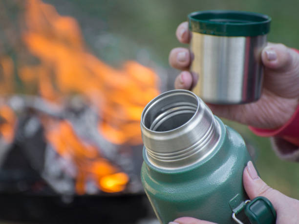istock Woman drinking a fresh tea  in outdoors near campfire. Drinking hot tea from a thermos. Thirst for something to drink. 1331922813