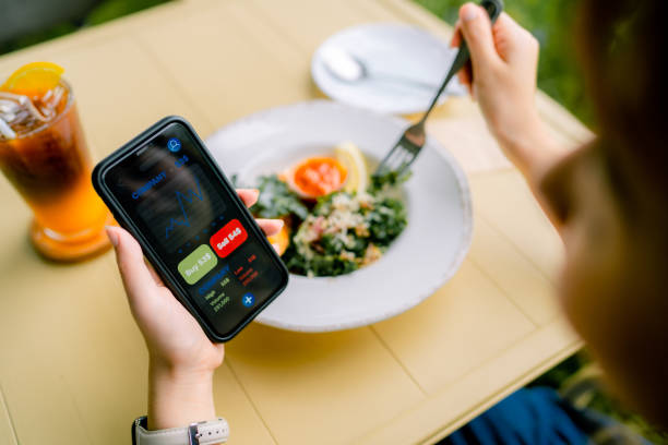 istock Young woman checking financial trading data with mobile app on smartphone while lunch in healthy restaurant. 1331924256