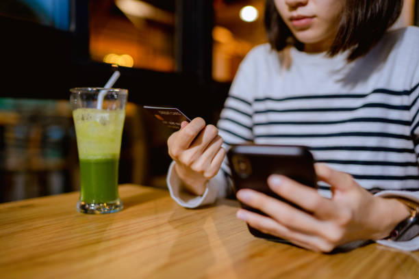 istock Woman online shopping on smartphone while relaxing at cafe. 1331924283