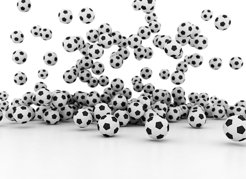 Many soccer balls falling on white background isolated