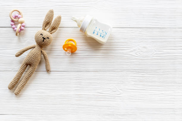 istock Child toy knitted rabbit with milk bottle, overhead view 1331926263