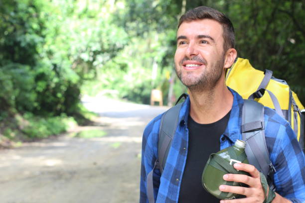 istock Guy walking in the jungle with water canteen 1331926407