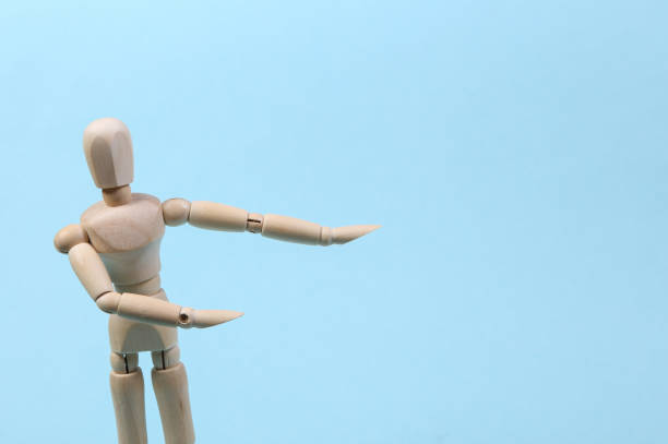 istock Wooden puppet mannequin shows on space for your text isolated on blue background. Copy space 1331926617