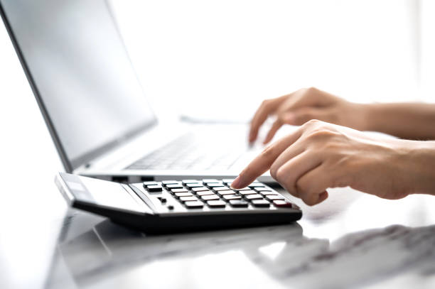 istock woman hand using calculator and laptop 1331926654