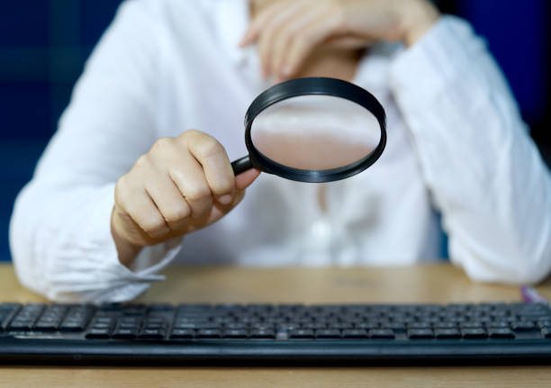 istock a businessman checks computer equipment with a magnifying glass Internet Information Security Concepts. 1331927239