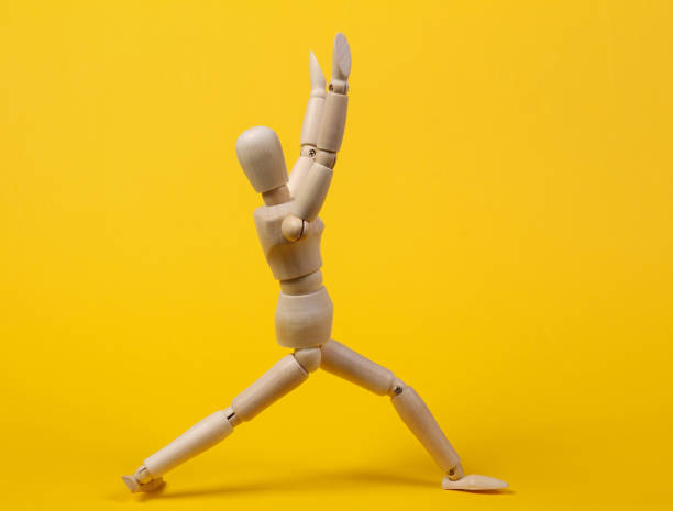 istock Wooden puppet practicing yoga asana pose on yellow background 1331927284