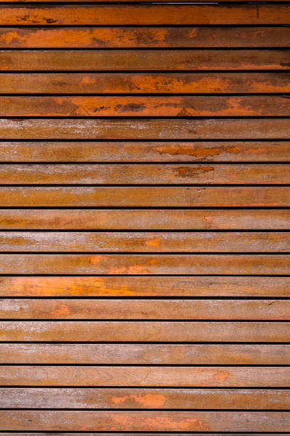 istock Old brown wood plank wall texture background. Rustic weathered barn wood background with knots and nail holes. 1331929596