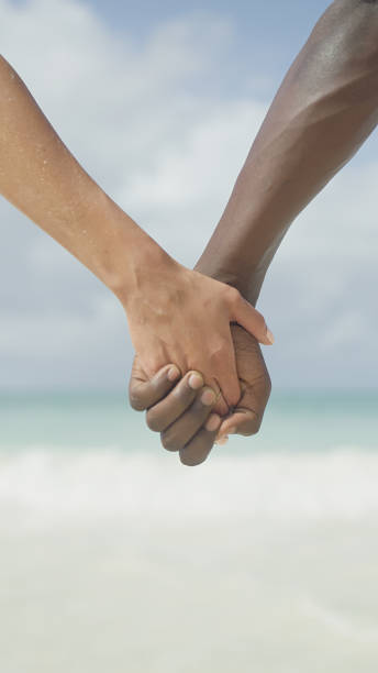 istock Diverse couple holding hands against turquoise sky and idyllic beach 1331932761