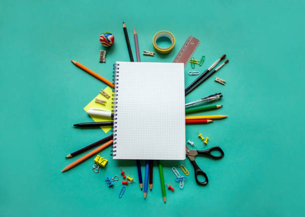 istock Spiral notebook with blank white sheet and colored chancellery on blue paper. The concept of office, school, creativity, learning. Top view, flat lay, copy space. 1331932963