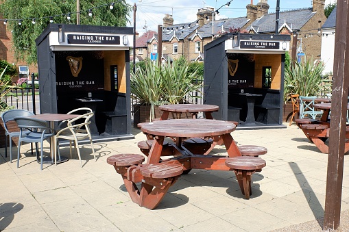 Rickmansworth, Hertfordshire, England, UK - August 2nd 2021: Wooden cabins sponsered by Guinness outside pub during the Coronavirus (Covid-19) pandemic