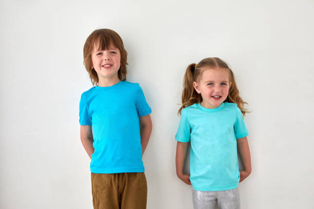 istock Cute siblings in blue t shirts against gray wall 1331935748
