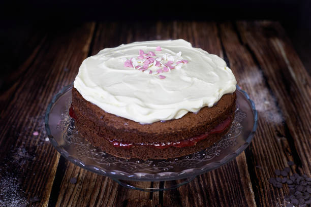 istock chocolate sponge cake with strawberry jam and cream topping 1331937367