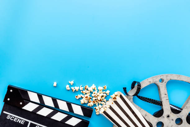 Movie film reel with clapperboard and popcorn. Cinema concept stock photo