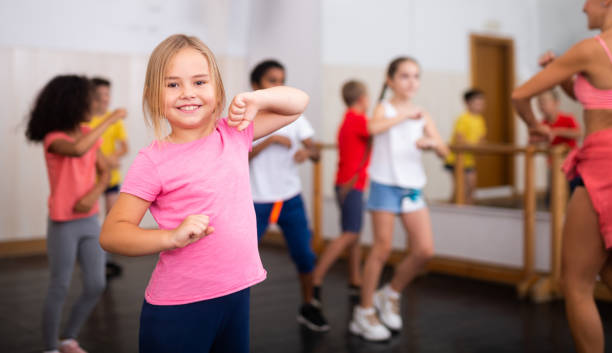 istock Smiling little girl training movements in children dance studio 1331943728