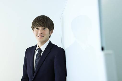 Portrait of Asian man in a business environment wearing a suit.