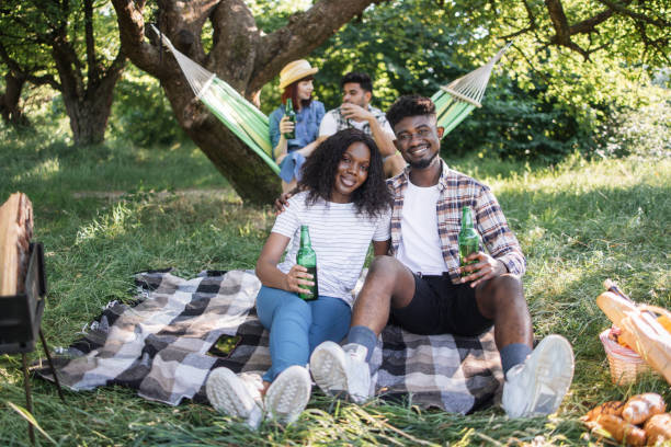 istock Four diverse friends enjoying picnic time on nature 1331947036