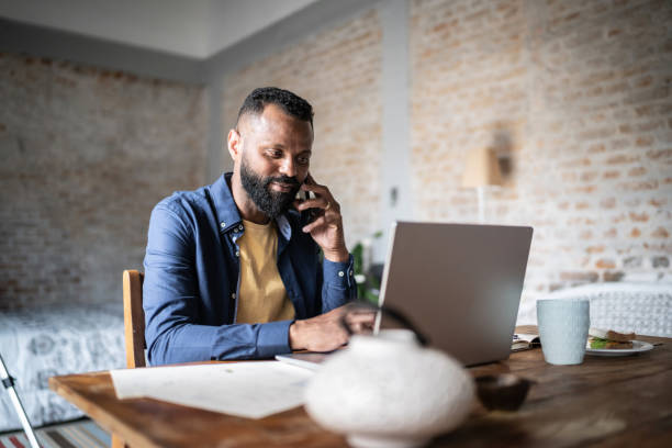 istock Mature man working using laptop and talking on the phone at home 1331948298