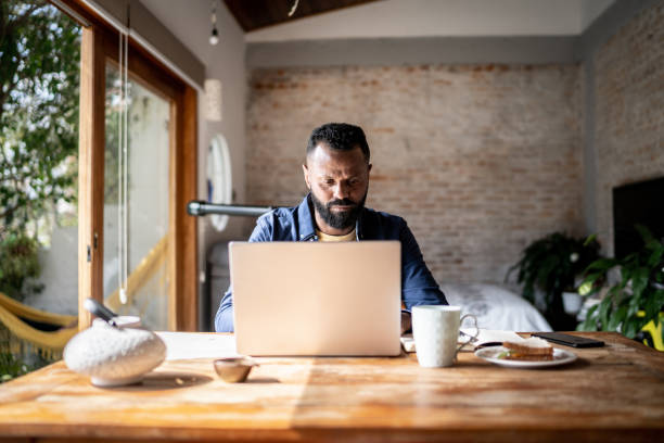 istock Mature man using laptop working at home 1331948300