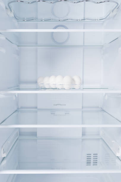 istock chicken eggs in a tray, in the refrigerator on a glass shelf, on a white background 1331948549