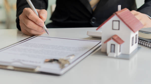 istock Businessman or home sales representative working with contract documents and calculators with laptops. To calculate interest, taxes and profits for real estate investments and home purchases. 1331949958
