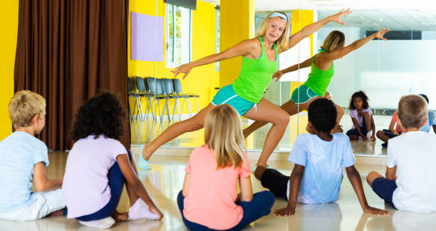 istock dance teacher giving children dance class showing movements 1331950015
