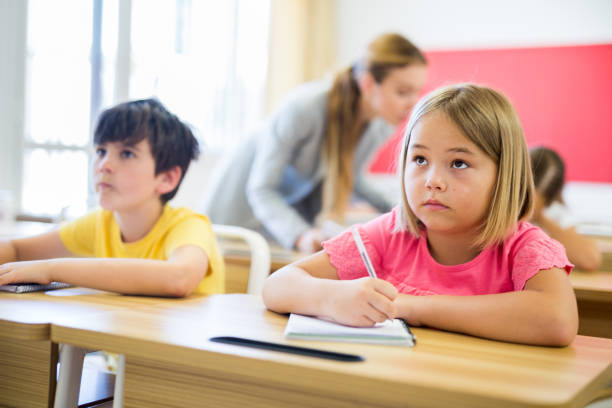 istock Teacher helping kids to complete exercises 1331951842