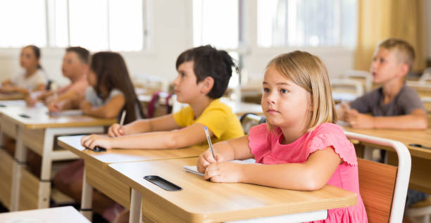 istock Schoolgirl sitting in classroom during lesson in elementary school 1331951980