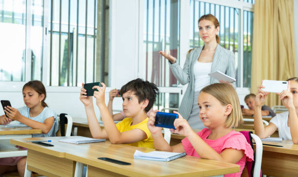 istock Pupils using mobile phones during lesson in school 1331951983