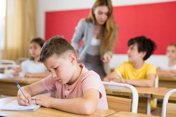 istock Schoolboy sitting in classroom during lesson in elementary school 1331952007