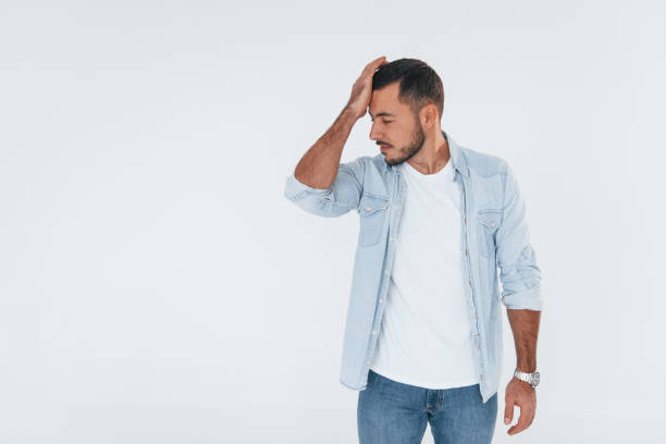 istock Feels bad. Young handsome man standing indoors against white background 1331952068