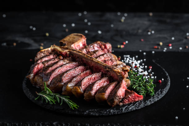 dry aged barbecue porterhouse steak or t-bone beef steak sliced with large fillet piece with herbs and salt. banner, catering menu recipe place for text, top view - beef meat t bone steak steak imagens e fotografias de stock