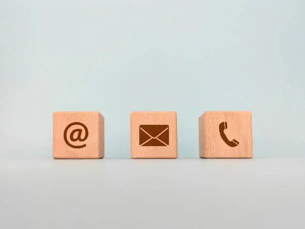 Contact us concept, wooden blocks with email, mail and telephone icons, web page contact us or e-mail marketing