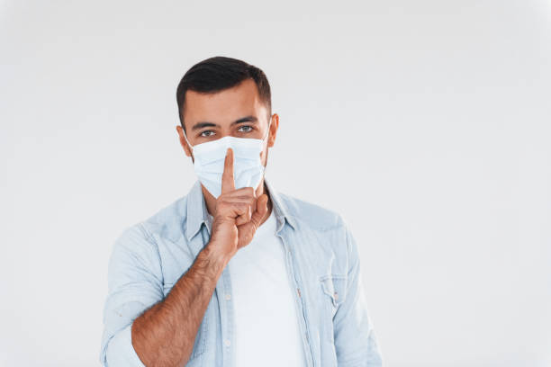 istock In protective mask. Young handsome man standing indoors against white background 1331955162