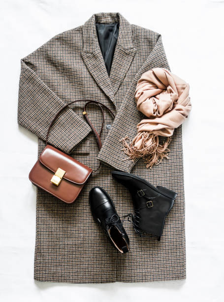 istock Women's autumn spring clothing  - oversized plaid coat, leather black boots, leather bag, beige cashmere scarf on a light background, top view. Fashion concept 1331956582